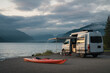 © Emanuel - Van parked at a lakeside campsite with a kayak ready for adventure