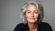 © Nataliia_Trushchenko - Woman with gray hair is smiling and looking at the camera. She is wearing a black shirt and she is posing for a photo