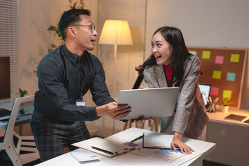 Young business team Young Asian woman discussing real estate project on tablet, laptop sitting at desk in office Two colleagues of professional business people working together teamwork concept.