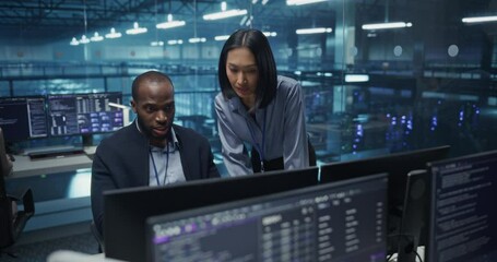 Poster - Black Male and Asian Female Engineer Collaborate on a Project in a Modern Data Center Office. Specialists Analyzing Complex Systems on Multiple Screens to Improve Cybersecurity and Performance
