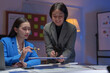 © crizzystudio - Two happy Asian businesswomen Discuss financial document work starting a business Creative team brainstorming meeting, business partnership or teamwork concept of office colleagues.