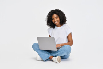 Happy young African American girl college student sitting isolated at white background using laptop computer advertising elearning course, online education webinars, internet websites and services.