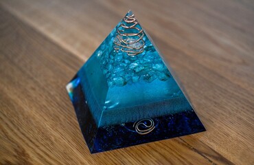 High resolution image of a single isolated beautiful one of a kind hand made Orgone pyramid generator containing crystals