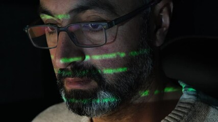 A software developer writing code in close-up. Hacker, cyber security, penetration testing concept. Screen light and computer code reflecting on his face. System administrator. 4K Resolution.