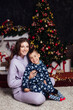 © dmitriisimakov - Mother and son at the Christmas tree with gifts for the new year