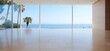 © MaMaKe - Empty room with large windows overlooking the ocean and palm trees.