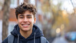 © Mahemud - Portrait of a smiling teenager on the street outdoors.