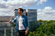 © Iryna - Confident man holding wind turbine model on rooftop