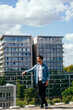 © Iryna - Young man in denim jacket on rooftop with cityscape view
