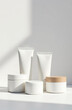 © Julia - Set of jars and tubes for cosmetics without labels, podium, mockup. Light background, shadows.