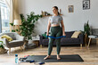 © Bliss - A sportive woman engages in her workout routine at home, feeling focused and energized in stylish activewear.
