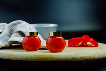 Two jars of red pepper jelly on table