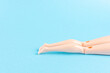 © Paopano - Creative composition with doll legs on blue background. Minimal summer vacation concept.