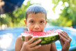 © Ljustina - Boy eating watermelon by the swimming pool