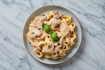 A photo of creamy pasta with chicken, basil, and mushrooms on a plate