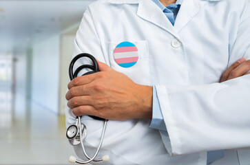 close-up of heart silhouette with transgender flag of doctor in white coat with stethoscope and tran