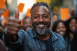 © David - Political candidate surrounded by supporters, giving a thumbs up and smiling.