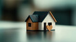 © altitudevisual - Miniature wooden house model with small heart shape attached, placed on blurred neutral background, representing concept of home and love.
