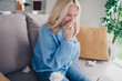 © deagreez - Portrait of nice aged lady sit sofa blow nose napkin wear sweater pastime weekend modern flat indoors
