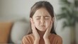 © pornchan - Child pulling ear with frown, living room, ear pain, common symptoms in children