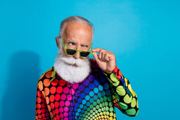 Photo of eccentric funky aged man touch sunglass look empty space wear shirt isolated on blue color background