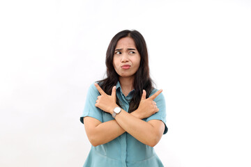 Confused young Asian woman with long dark hair points sideways with index fingers chooses between two options dressed in casual shirt isolated white background