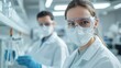 © saichon - Two scientists in lab coats and protective gear conduct experiments in a modern laboratory, focusing on safety and research.