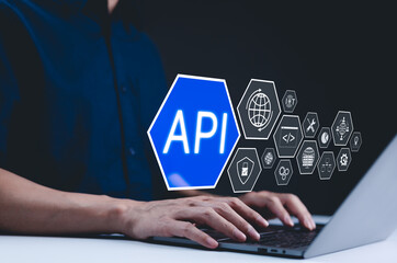Wall Mural - api - application programming interface concept. a programmer types on a laptop, with digital icons 