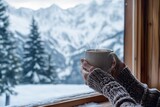 A person holding a cup of hot chocolate, standing by a window with a view of snowy mountains, cozy cabin 1