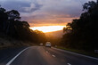 © Austockphoto - Golden sunset haze in sky above dark road late in the day as cars travel on rural highway