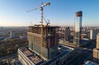 © Supittra - Aerial View of Modern Building Under Construction with Cranes and Scaffolding in Urban Landscape