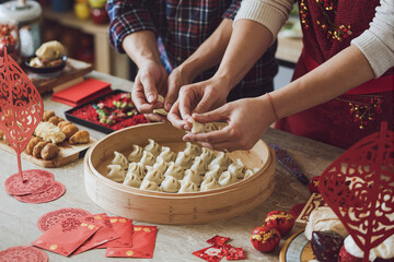 Couple preparing traditional dumplings for chinese new year celebration