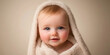 © Jaruwan photo - soft, warm image of baby wrapped in fluffy towel, showcasing joyful expression and bright blue eyes. gentle tones create cozy atmosphere
