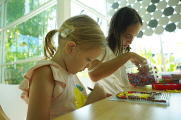 Teacher in workshop teched two girls how to assemble a thermo mosaic 