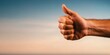 © Denis Tuev - a hand showing the 'thumbs up' gesture (like), close-up, on a light background. The left side of the frame is free for text. The smallest details of the texture of the skin and nails are visible.