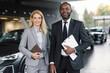 © Oleksii Syrotkin/Stocksy - Saleswoman and salesman standing among brand-new vehicles in showroom