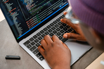 A man is programming on a laptop in the office