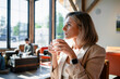 © DZ FILM/Stocksy - A woman drinks coffee in a cafe