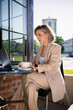 © DZ FILM/Stocksy - A woman uses a laptop sitting on a cafe terrace