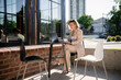 © DZ FILM/Stocksy - A woman uses a laptop sitting on a cafe terrace