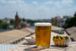 Spanish beer and bowl with green andalusian olives served on outdoor roof terrace with view on central part of old Sevilla, Andalusia, Spain