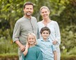 © peopleimages.com - Happy family, portrait and hug outdoor for relax, love and embrace on weekend with support at home. Parents, smile and face in backyard for holiday, bonding and joy with children, trust and care