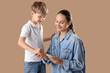 © Pixel-Shot - Little diabetic boy with his mother using glucometer on brown background