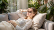 ©  Princess Turandot - Tired woman resting on couch with hand on forehead, experiencing stress and fatigue