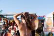 © Eloisa Ramos/Stocksy - Girl Fixing Hair at Beach Equipment Rental Stall