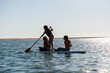 © Eloisa Ramos/Stocksy - Girls Paddleboarding on Calm Ocean