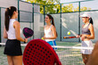 © Adrian Rodd/Stocksy - Athletic friends enjoy a sunny summer day on a paddle tennis court