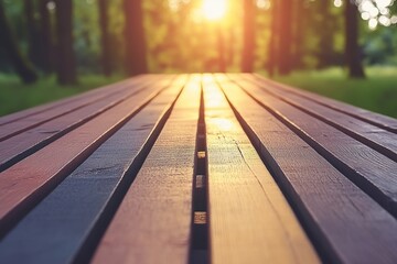 Wooden picnic table with warm evening sunlight shining through the trees in the background.