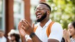 © LifeMedia - A young man wearing glasses and a backpack applauds heartily during a vibrant outdoor academic event, expressing learning and enthusiasm.