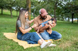 © Alvaro Lavin/Stocksy - Venezuelan family relaxing in park with their sleeping baby girl